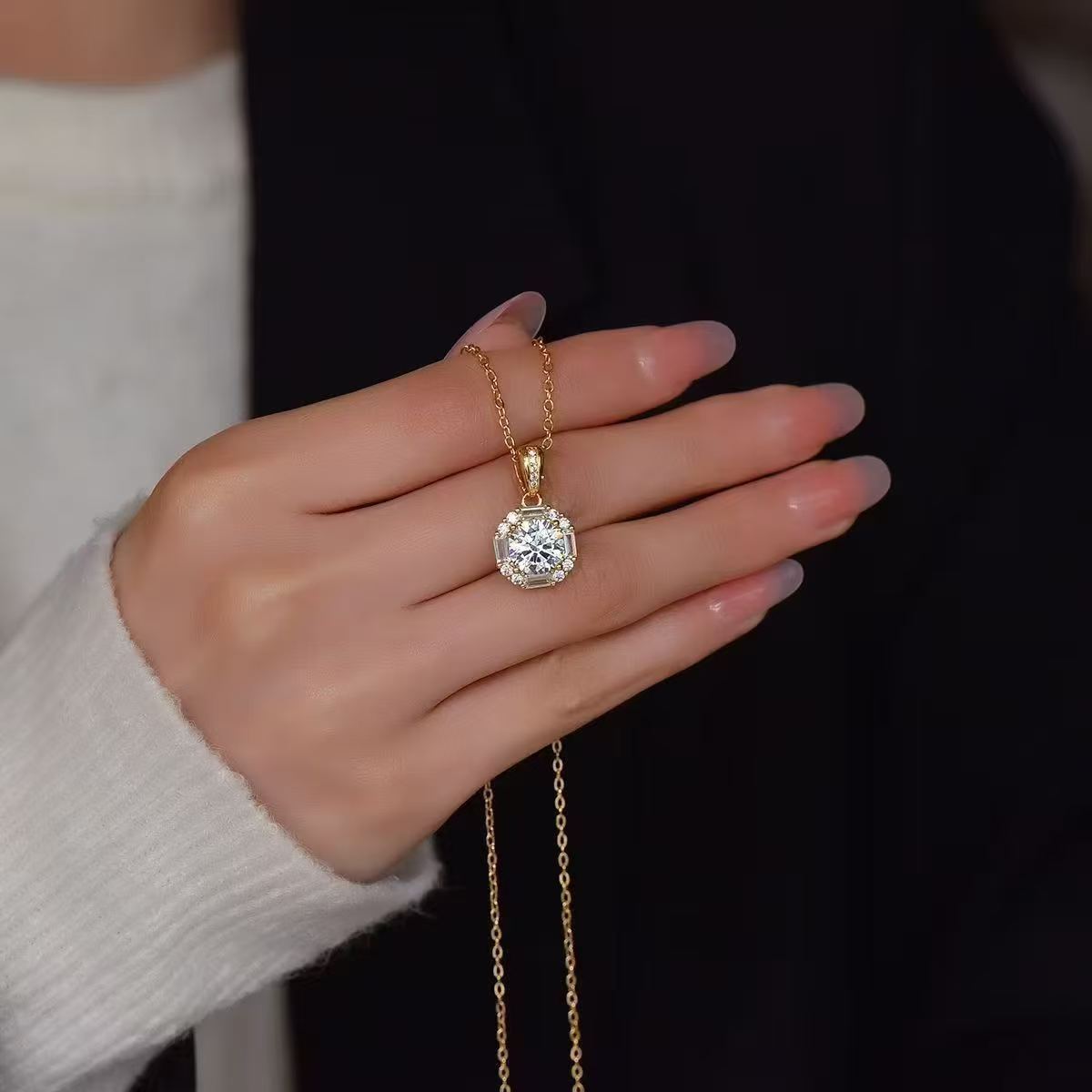 Laboratory-grown diamond pendant held in the hand